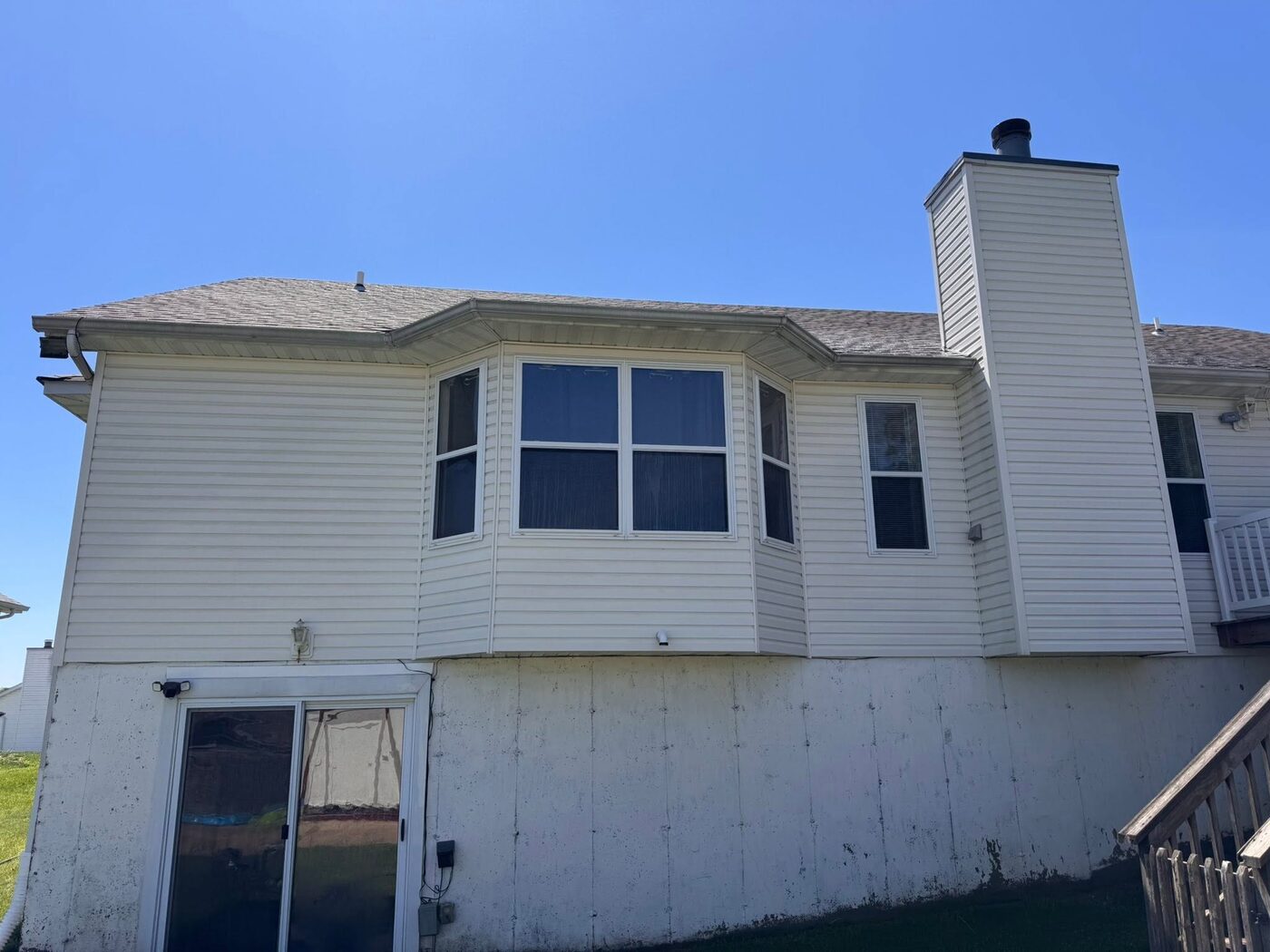The same home after a soft wash, with the siding back to clean cream white