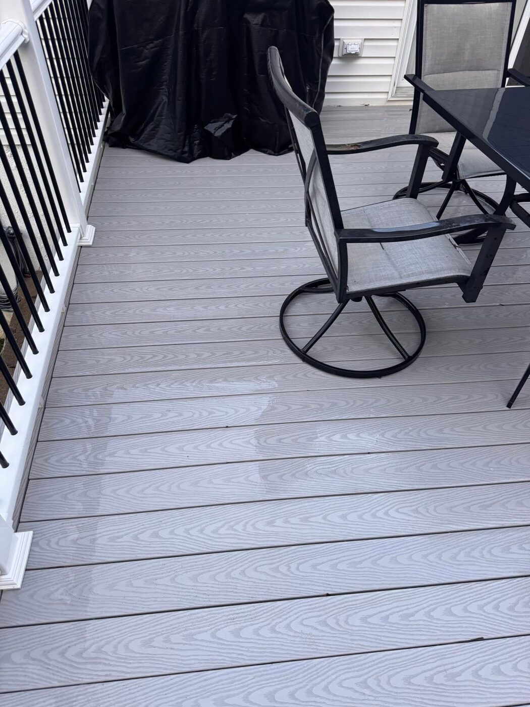 Grey composite deck boards cleaned around patio furniture
